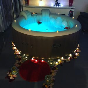Spa gonflable décoré avec lumières, pétales et ambiance romantique