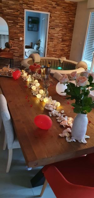 Table décorée avec pétales, lumières et spa Dans Ma Bulle en arrière-plan.