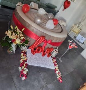Spa Dans Ma Bulle décoré avec pétales, ballons argent et rouges, décoration love.