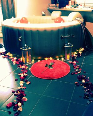 Spa Dans Ma Bulle décoré avec pétales, lumières chaudes et lanternes pour une soirée romantique.
