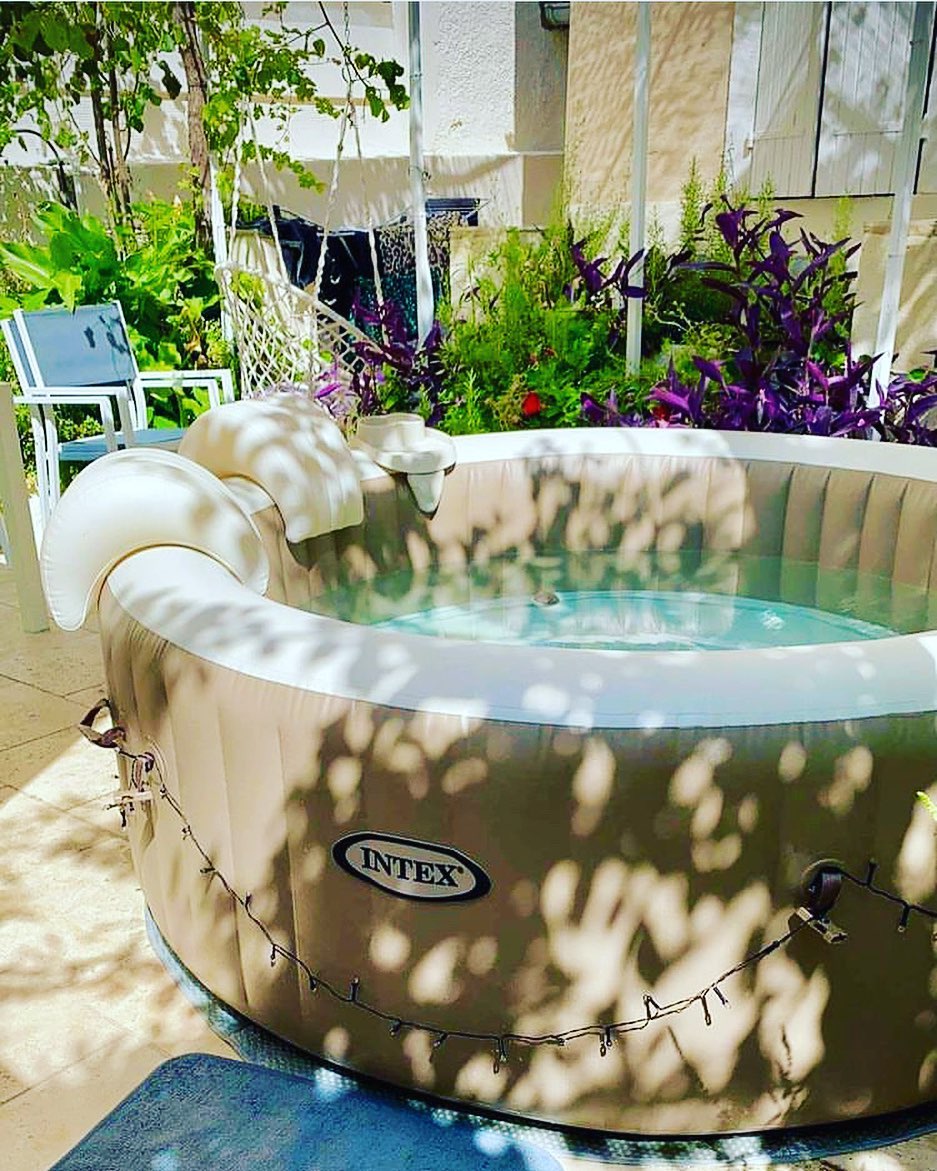 Spa gonflable Intex installé en extérieur sous l’ombre des arbres avec jeux de lumière naturelle