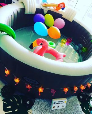 Spa gonflable décoré en intérieur avec flamant rose gonflable et ballons colorés.
