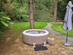 Spa gonflable installé dans un jardin entouré d’arbres