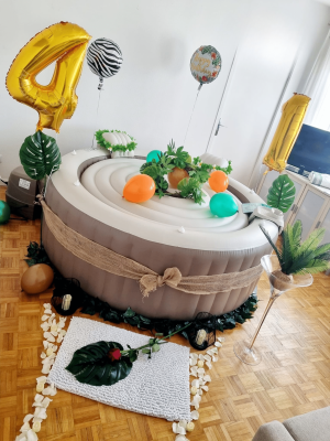 Spa gonflable décoré en thème jungle avec ballons, végétation et décoration d’anniversaire pour un enfant.