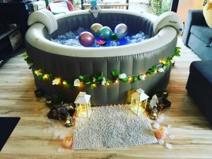 Spa intérieur décoré avec fleurs blanches, lanternes et guirlandes lumineuses.